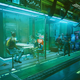 Patrons sit in booths at the Afterlife bar in Cyberpunk 2077.